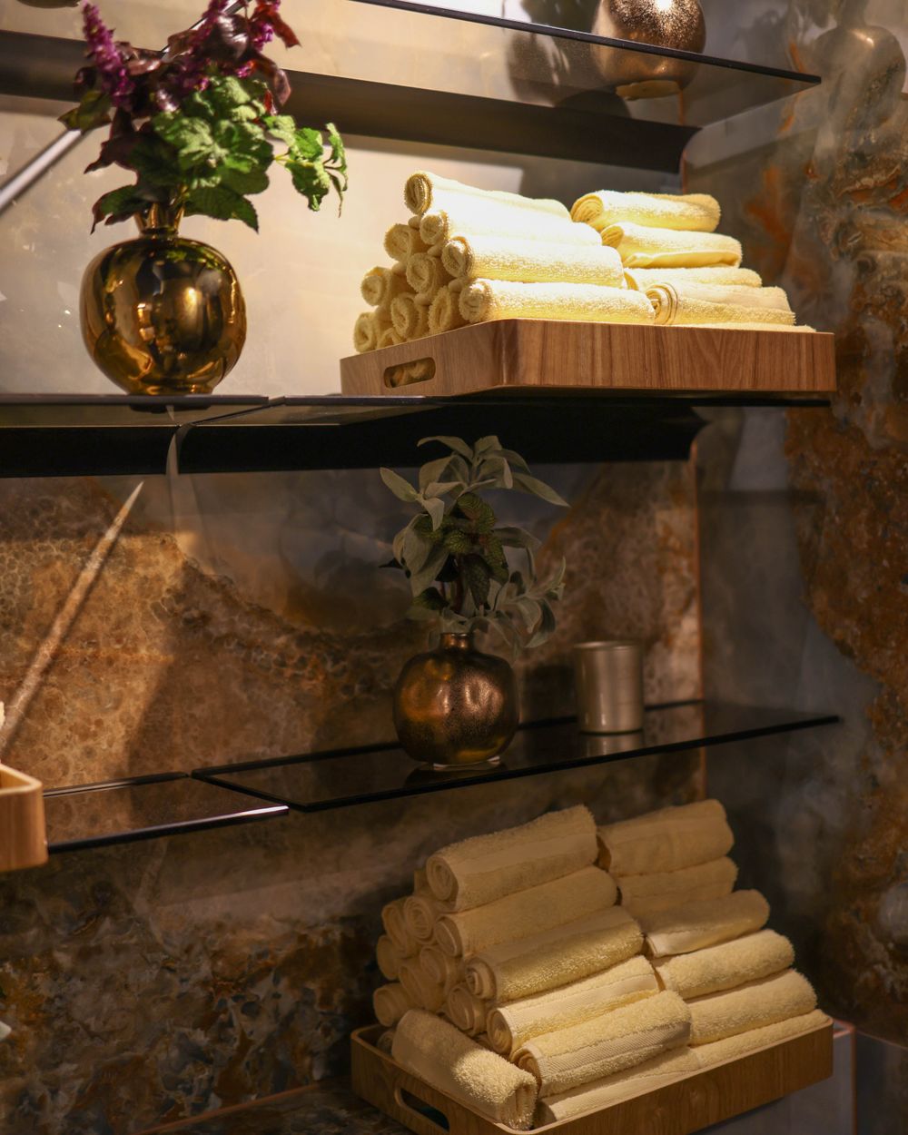 Spa detail — folded towels, botanicals, and warm brass accents